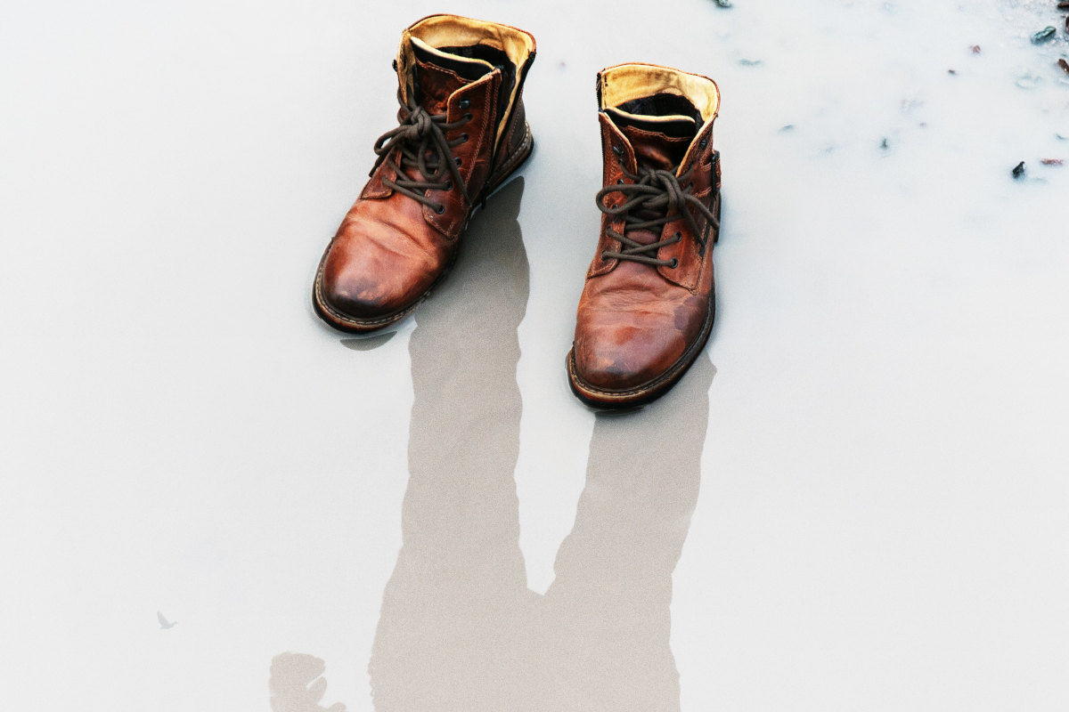 Pair of boots with a man's shadow overimposed