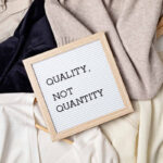 Flat lay of clothes and hangers; assortment of women's clothing. Second hand sustainable shopping; capsule minimal wardrobe; slow fashion idea; quality not quantity concept