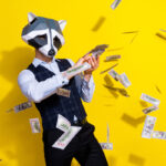 Photo of crazy bizarre authentic guy racoon mask waste billion dollars lottery win jackpot isolated over shine yellow color background